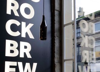 Distinctive Magic Rock typography reflected onto the window showing the Holmfirth street outside
